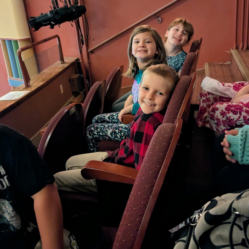 students sit in theater seats